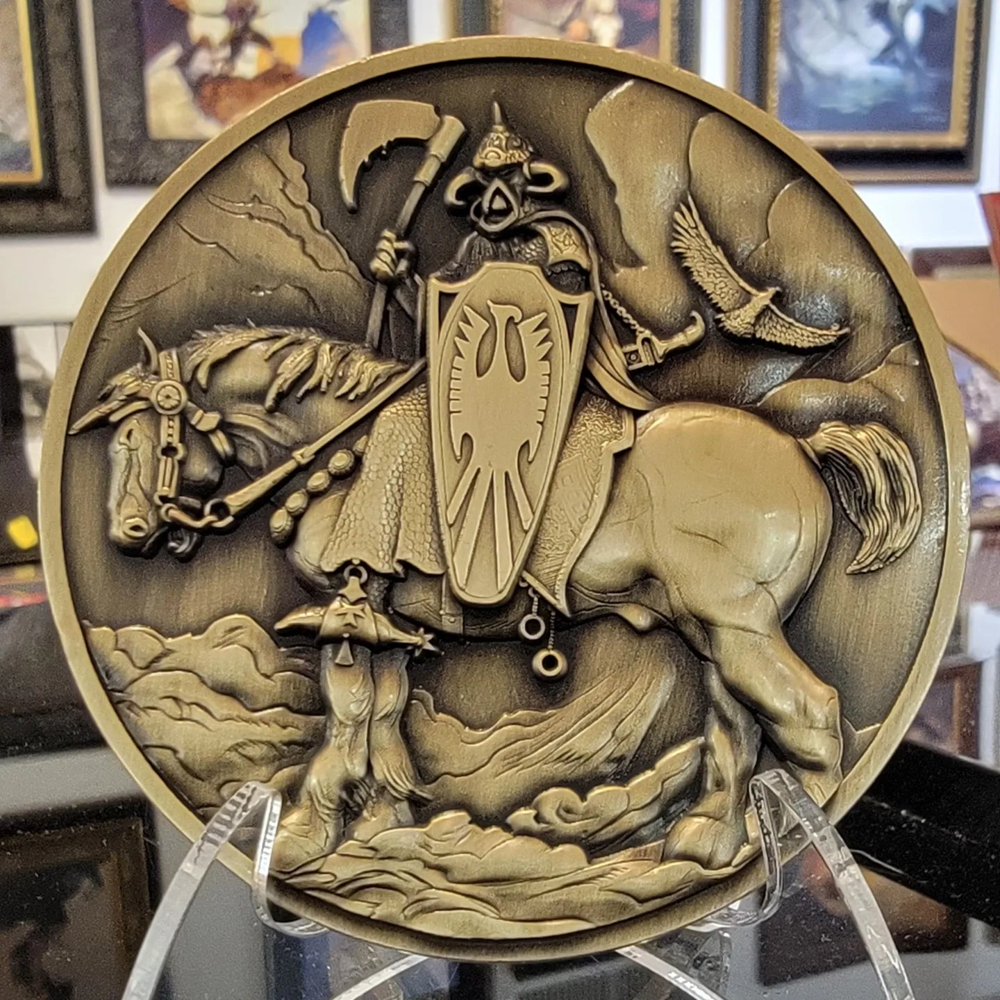 Death Dealer coin photographed at the Frazetta Museum with paintings in the background